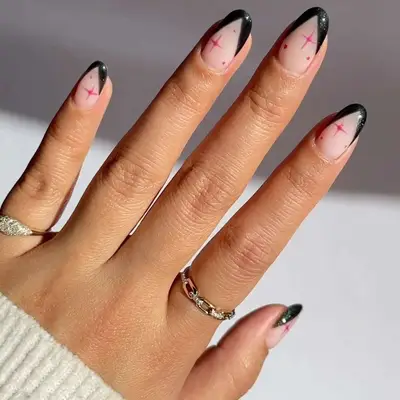 Manicure with black French tips with subtle shimmer and pink sparkle designs