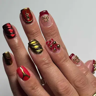 Mismatched manicure with deep red and gold chrome 3D accents and 
