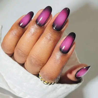 Close-up of pink and black aura design manicure