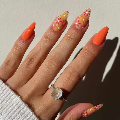 Orang almond-shaped nails with warm-toned daisy accents - MYM Beauty Festival Nails
