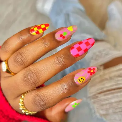 Bright mismatch nails with pink, orange, red, yellow, and green checker, cherry, smiley, and flower nail art - MYM Beauty Festival Nails