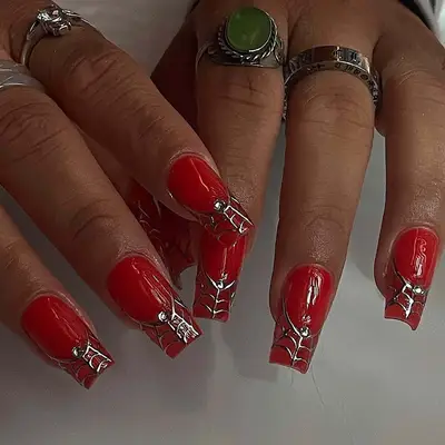 a square red manicure with silver web tips