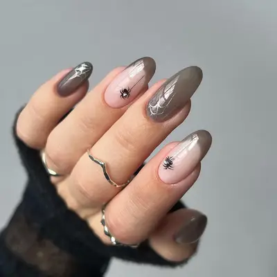 a sheer gray manicure with spider and chrome web details