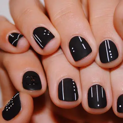 Matte black nails with white lines and dots