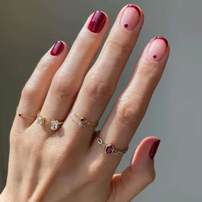 Deep red manicure with French tip accent nails with matching dots at base