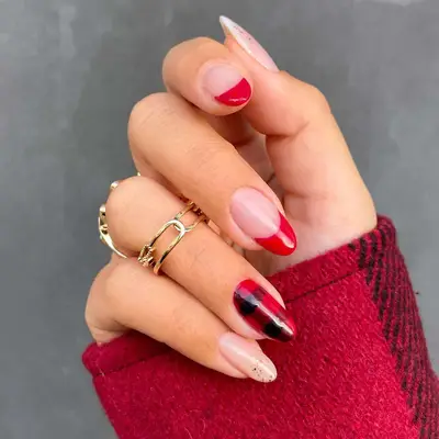 Manicure with two red French tips, two glitter French tips, and a plaid accent nail