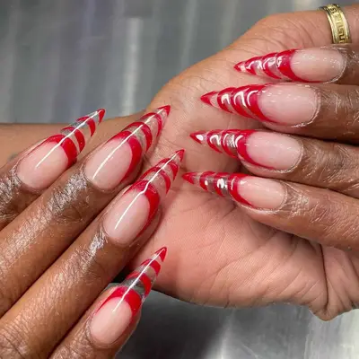 Red French manicure with long unicorn horn-inspired tips