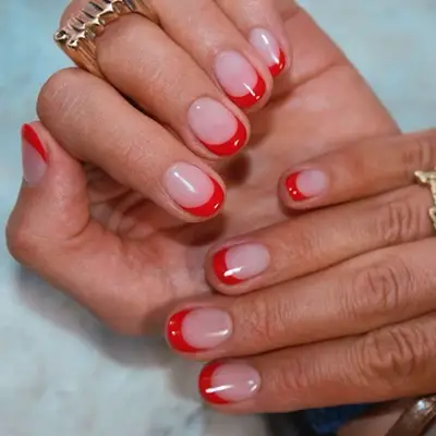 Red French tip manicure with thick crescent tips