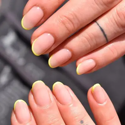 Short nude rounded nails with ultra-thin neon yellow french tips