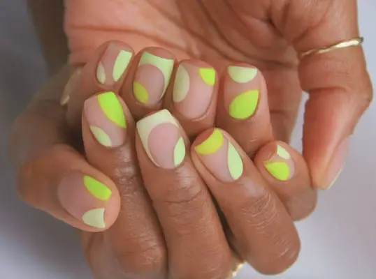 Negative-space manicure with lime green neon designs on square nails