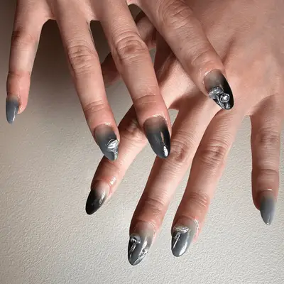 Gray and black chrome French nails with silver 3D mushrooms.