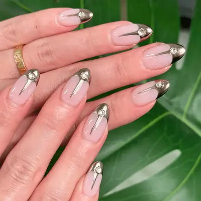 Gold French tips nails with crystal gems.