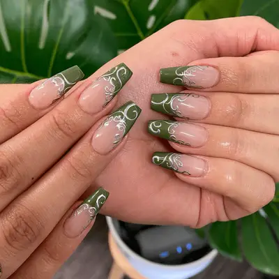 Green French nails with silver chrome swirl nail art.