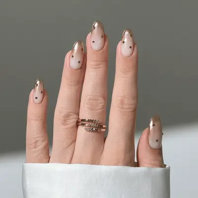 Gold French nails with gold gem details.