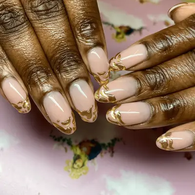 Nude nails with gold chrome droplet French.