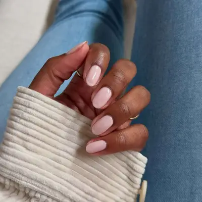 Baby pink polish on short natural nails