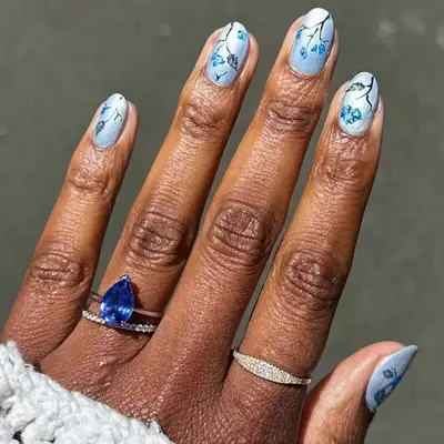 Manicure with pastel blue polish and leaf design