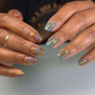 Manicure with iridescent colors and gold chrome structures.