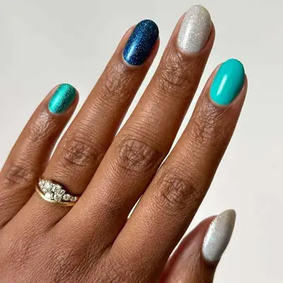 Glitter manicure with solid light blue accent nail