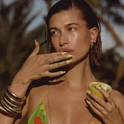 Hailey Bieber wearing pale yellow long almond mani