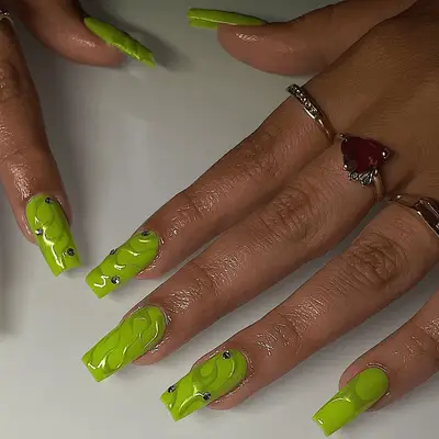Long square neon green nails with metallic swirls and silver gems