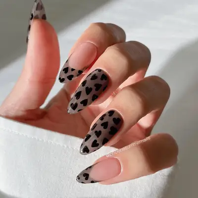 Black jelly nails with heart designs and French tips