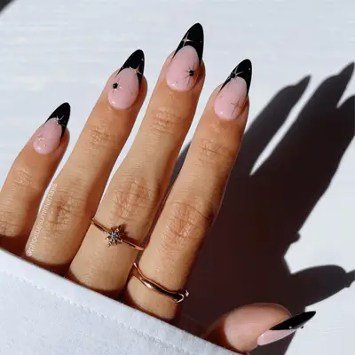 Black French manicure with gold chrome star details