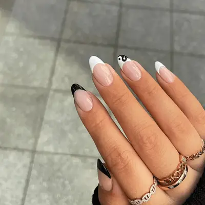 White and black French manicure tips with yin-yang detail.