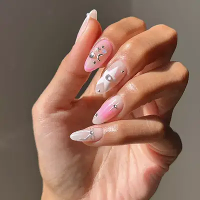 pinks nails with celestial details like stars and moons
