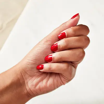Woman with a completed red manicure