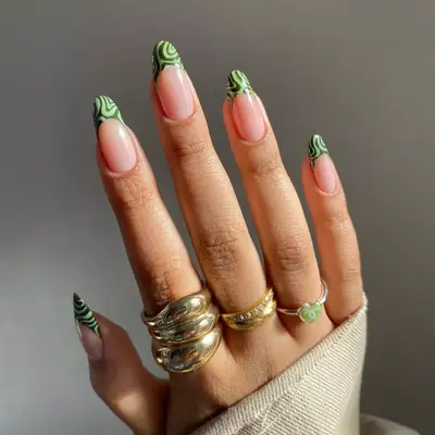 model with French tips with dark green and medium green swirls