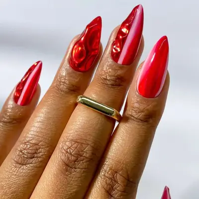 a red and pink manicure with chrome and 3D designs