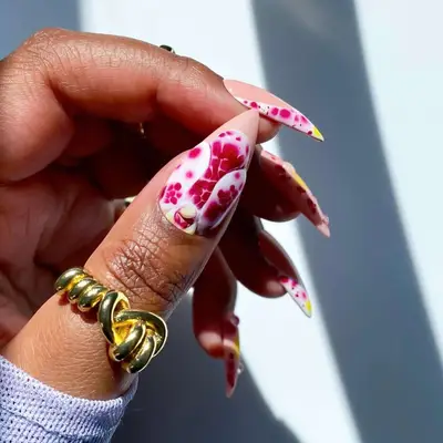 a detailed orchid nail design on a thumb