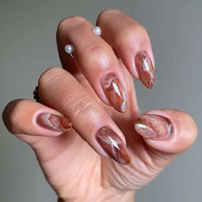 a brown and white creamy marble manicure