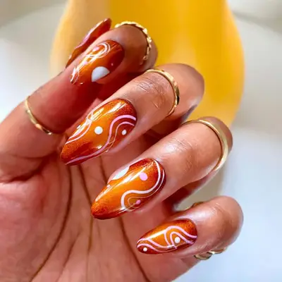 Toasted Aura nails with white and pink designs on top 