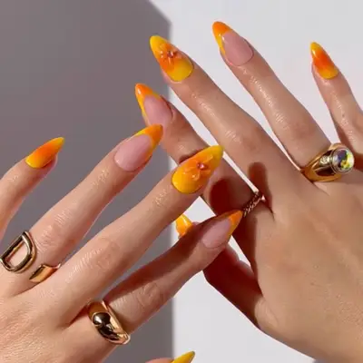 a yellow and orange aura manicure with 3D gel designs
