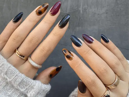 dark skittle manicure with burgundy, green and tortoise designs