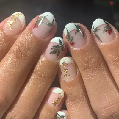 French manicure with gold foil details and red cranberry designs