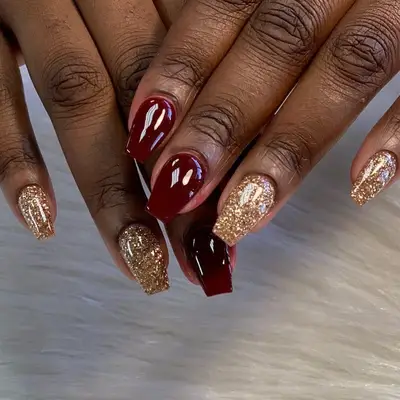 Oxblood red and glittery gold manicure