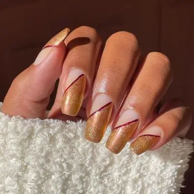 Negative space nails with gold diagonal section and red dividing line