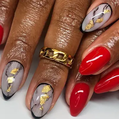 Red manicure with gold foil marble accent nails