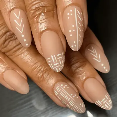 Nude almond shaped nails in matte finish with minimalist white mudcloth-inspired print