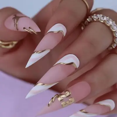 pierced and pointed stilleto nail manicure with pink and white and gold details