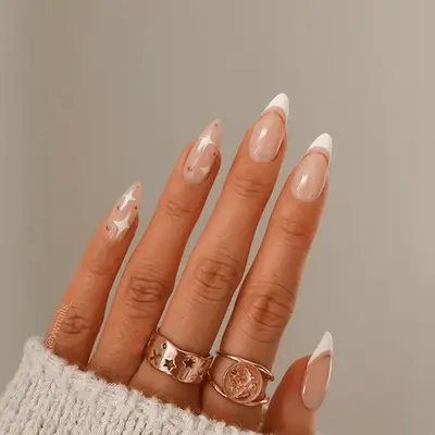 simple stilletto nail manicure with french tips and gold star details