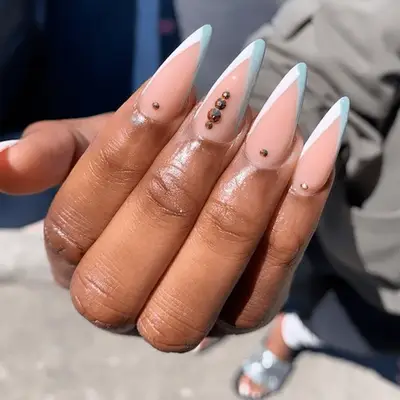 stilletto nails with blue and white tips and crystals