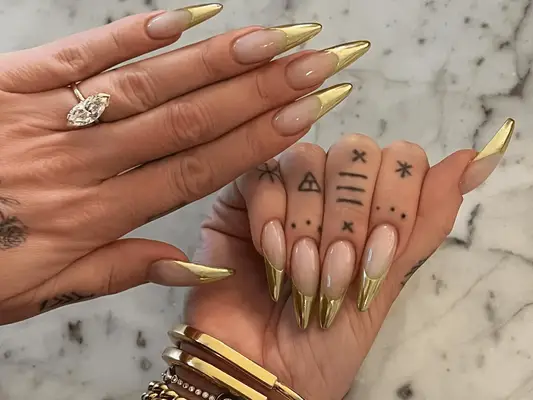 French manicure with metallic gold tips on pointed stiletto nails