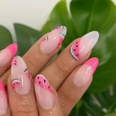 a strawberry milk manicure topped with watermelon and french tip designs