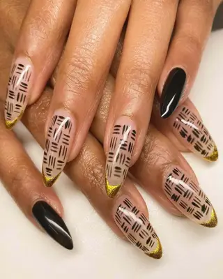 Almond nails with black cross-hatch design and gold tips 
