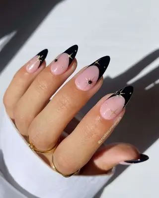 French manicure with black tips and gold star designs