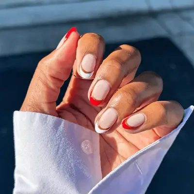 Half moon French manicure with red and gold detail